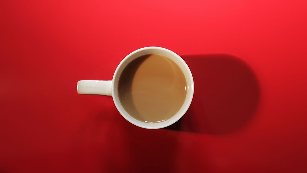 chávena de café sobre mesa vermelha